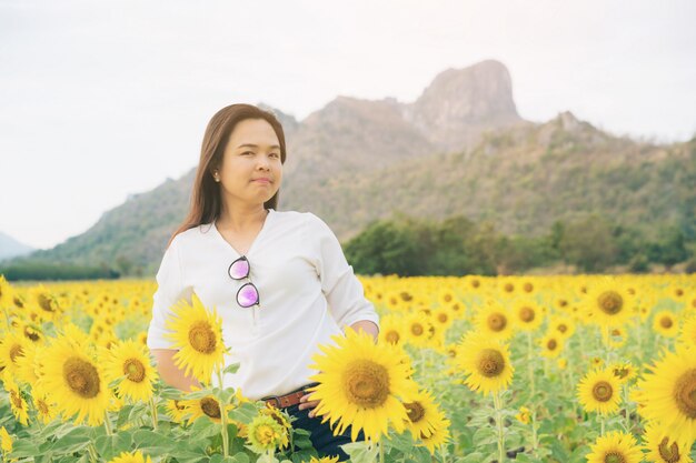 Vrouw die zich op zonnebloemgebied bevindt