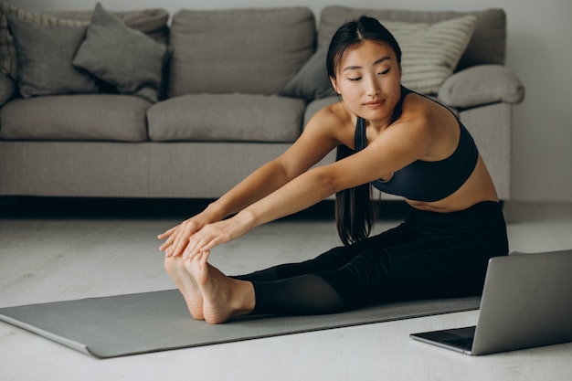 Vrouw die zich thuis uitstrekt op yogamat