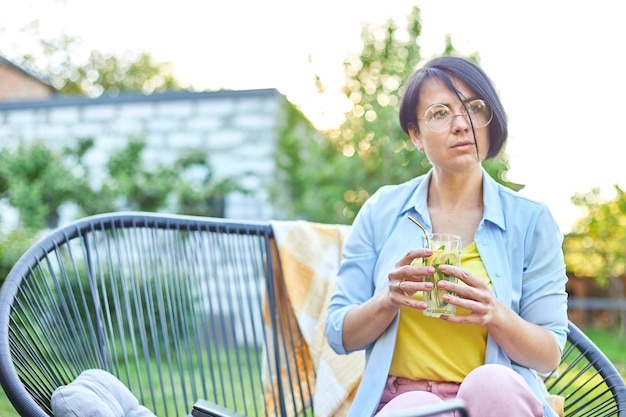 Vrouw die zomercitruslimonade drinkt met herbruikbare metalen rietjes party