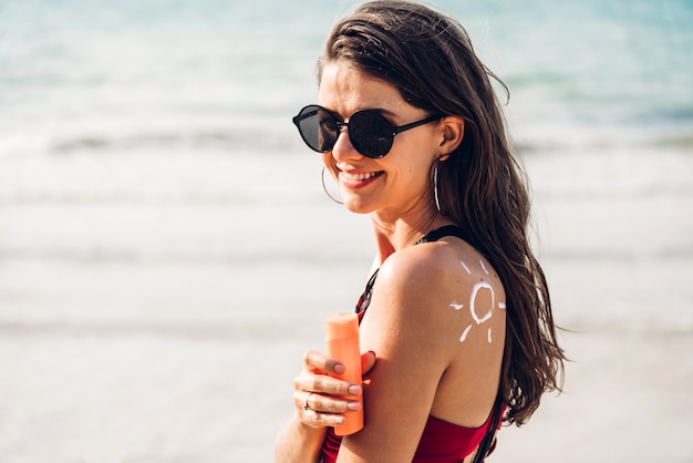 Vrouw die zonnescherm draagt bij het strand