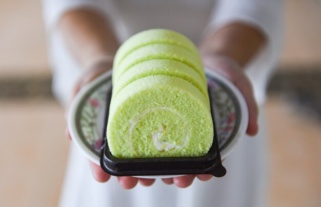 Vrouw diende groene pandan cakebroodje met room