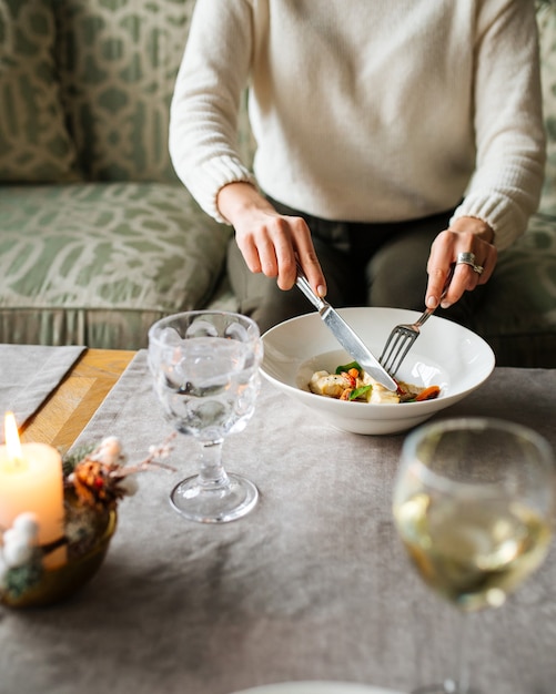 Vrouw dineren met gekookte kabeljauw vissen zittend op de bank