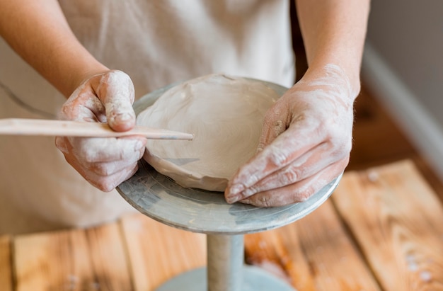 Foto vrouw doet aardewerk in haar atelier