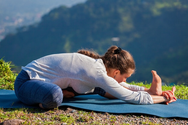 Vrouw doet Ashtanga Vinyasa yoga Janu Sirsasana asana