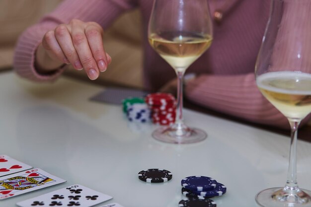 Vrouw doet een zet in een spelletje poker Chipkaarten glazen champagne op tafel met reflectie Lifestyle fotografie