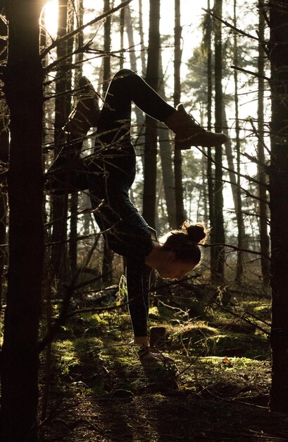 Foto vrouw doet handstand in het bos