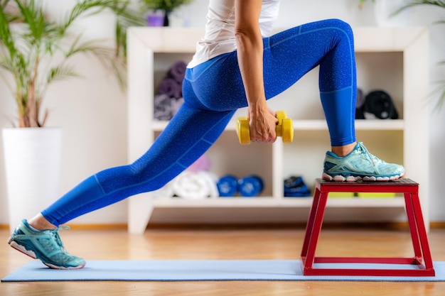 Vrouw doet lunges met halters op springkruk