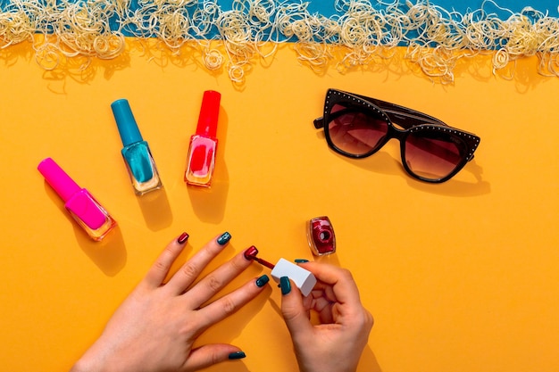 Vrouw doet manicures met verschillende nagellakken zomer levendige kleuren