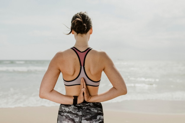 Vrouw doet namaste achter haar rug