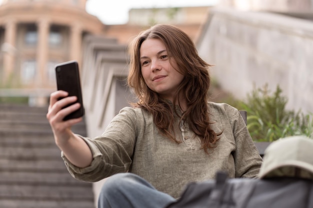 Vrouw doet selfie met telefoon buitenshuis