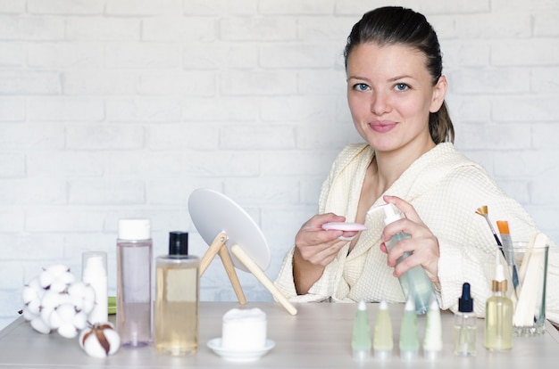 vrouw doet spa-procedures met behulp van natuurlijke cosmetica.