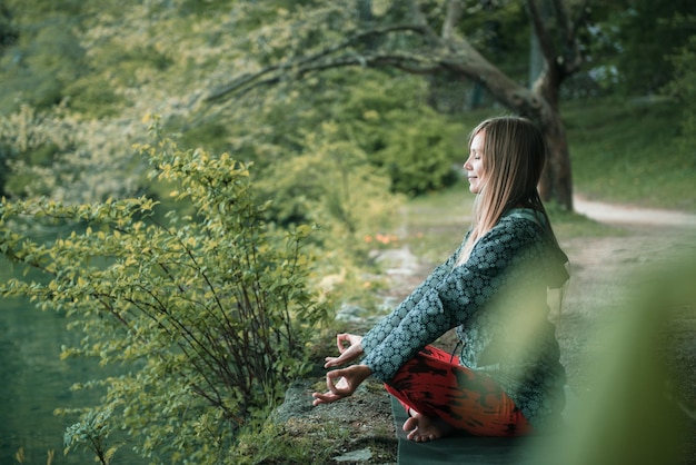 Foto vrouw doet yoga bij het meer.