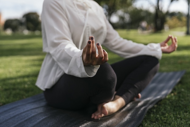 Vrouw doet yoga buiten in een park