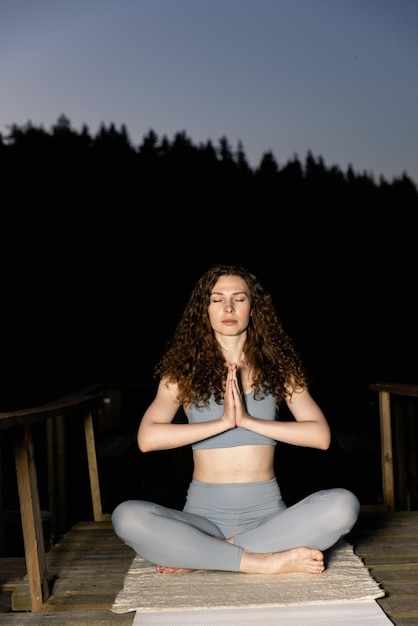 vrouw doet yoga buiten in het bos