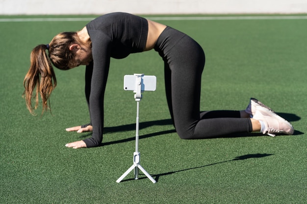 Vrouw doet yoga oefening genaamd cat pose buiten