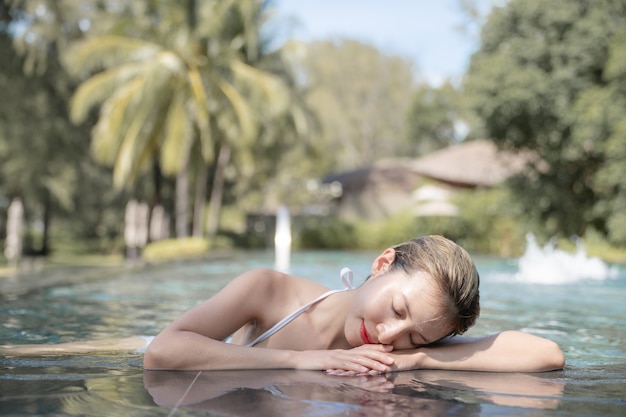 Vrouw draagt bikini ontspannen in het zwembad. spa-behandelingen concept.