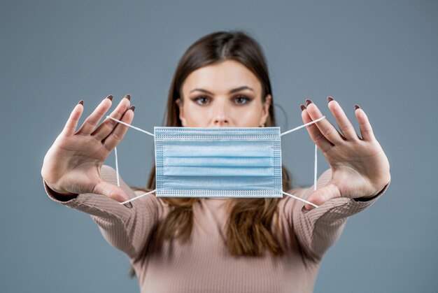 Vrouw draagt een anti-virus beschermingsmasker Vrouw draagt medisch gezichtsmasker Meisje draagt beschermend masker