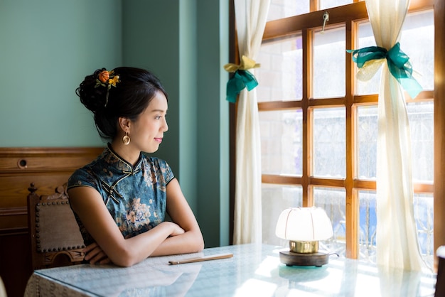 Vrouw draagt traditionele Chinese cheongsam in het vintage restaurant