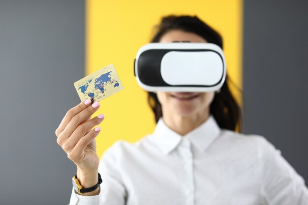 Vrouw draagt virtual reality-bril in haar handen, ze houdt bankcreditcard