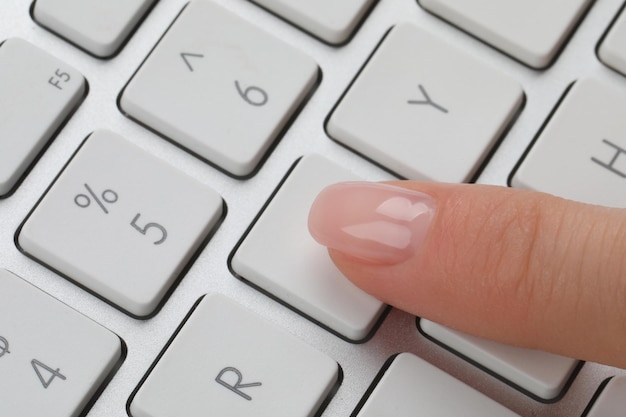 Vrouw dringende knop op computer toetsenbord close-up