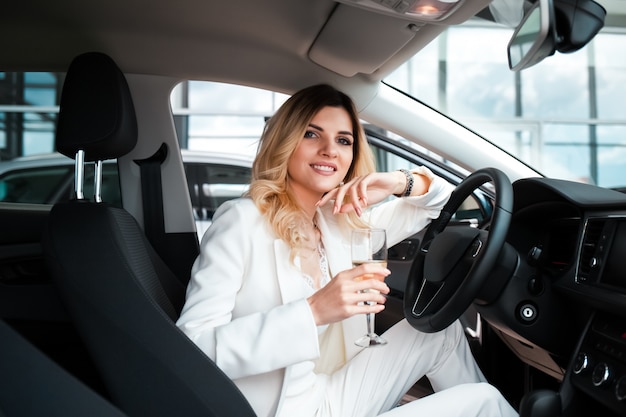 vrouw drinkt champagne in de auto