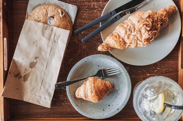 Vrouw drinkt croissants en ijskoude citroenthee in het café