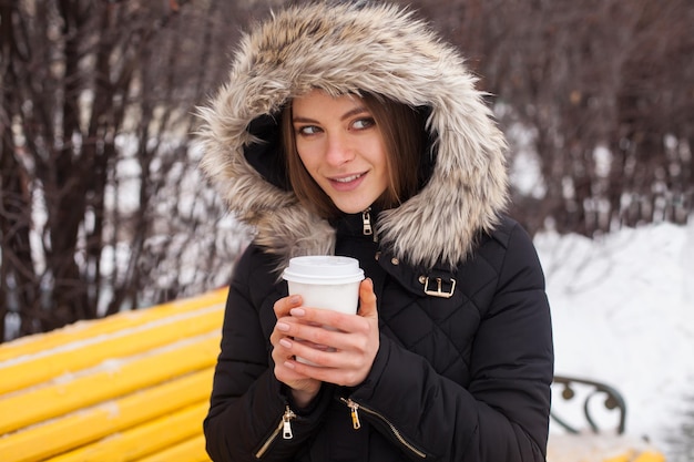 Vrouw drinkt haar warme drank uit beker Winterseizoen