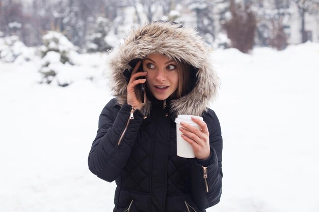 Vrouw drinkt haar warme drank uit beker Winterseizoen