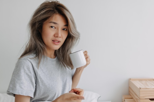 Vrouw drinkt koffie in de ochtend op het bed