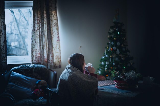 Foto vrouw drinkt koffie thuis tijdens kerstmis