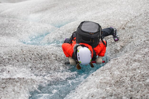 Vrouw drinkt water bij een beek op sneeuw