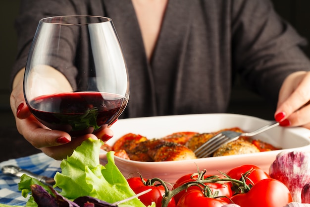 Vrouw drinkt wijn gebraden kip op de tafel