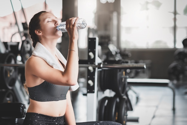 Vrouw drinkwater uit de fles na training