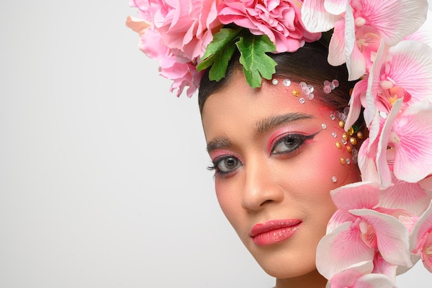 Vrouw droeg roze make-up en versierde prachtig de bloemen geïsoleerd op wit