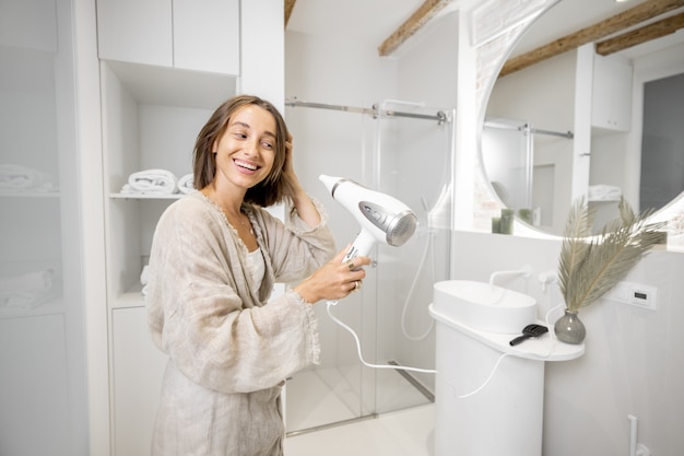 Vrouw droogt haar in modern badkamerinterieur