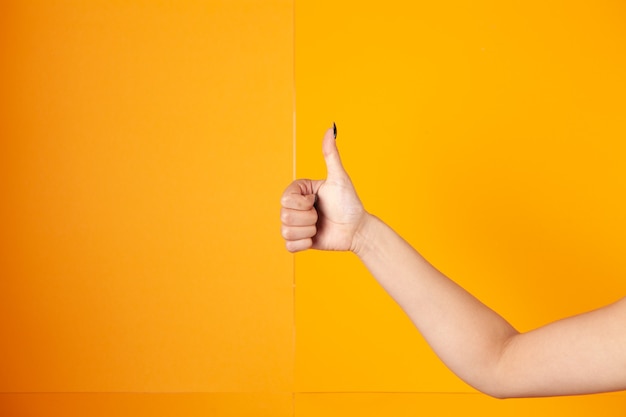 Vrouw duim opdagen op oranje background