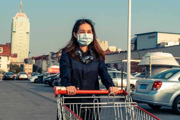 Vrouw duwen winkelwagentje op de parkeerplaats