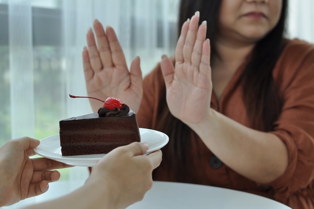 Vrouw duwt de plaat met een chocoladetaart