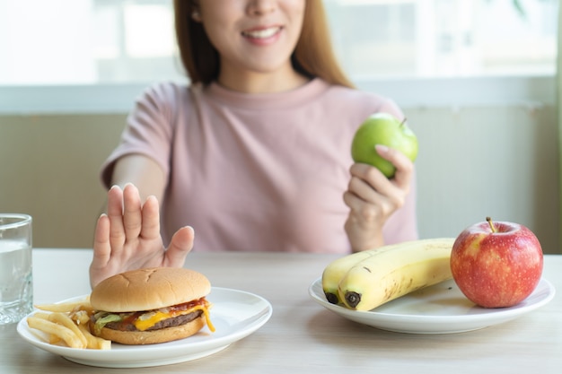 Vrouw duwt fastfood weg en kiest appel