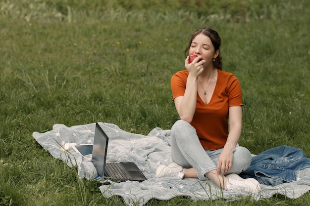 Vrouw eet appel in park