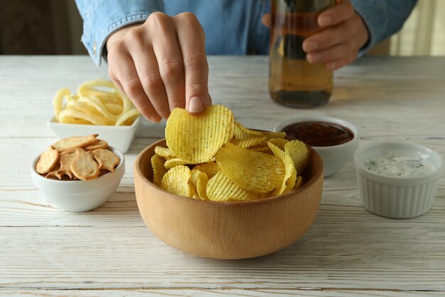 Vrouw eet chips en drinkt bier, close-up