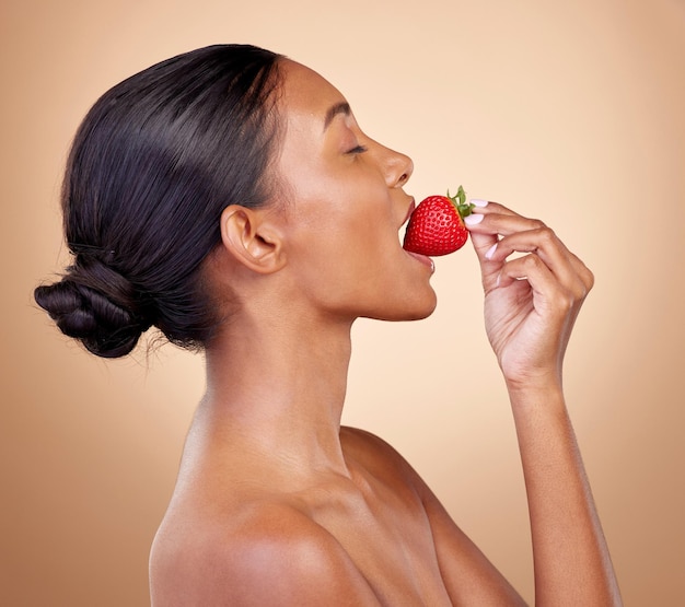 Vrouw eet een aardbeien en huidverzorging met natuurlijke schoonheid of voordelen van gezonde voeding dieet en fruit Meisje profiel en voedsel met vitamine c voor huid om te gloeien schitteren of welzijn van het lichaam