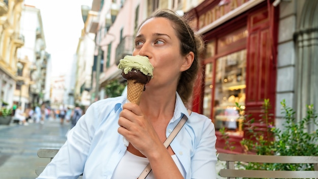 Vrouw eet een ijsje in Sanremo, Italië