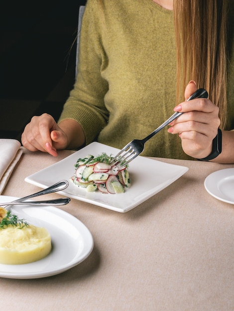 vrouw eet haar lunch in restaurant fish and chips salade met radijs