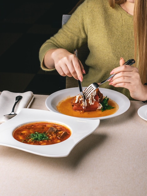 vrouw eet haar lunch in restaurant koolrolletjes en geroosterde paprika en soep Borsch
