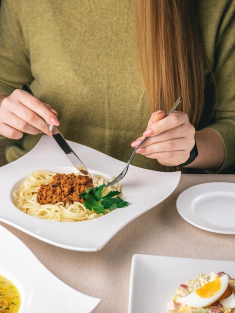 Vrouw eet haar lunch in restaurant pasta met vlees