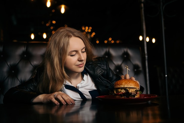 Vrouw eet hamburger in café