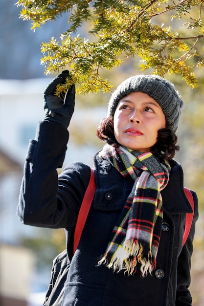 Vrouw en de pijnboombladeren met zonneschijnachtergrond.