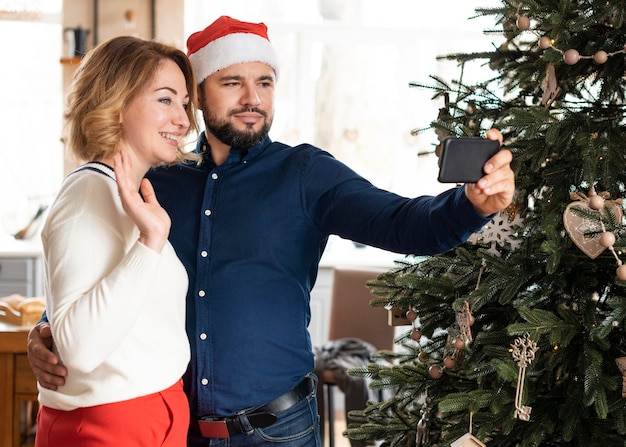 Foto vrouw en echtgenoot die samen een selfie op kerstmis samen nemen