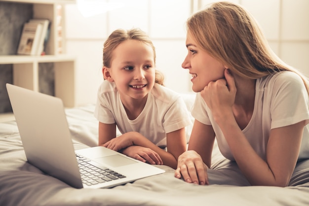 Vrouw en haar schattige kleine dochter gebruiken een laptop.